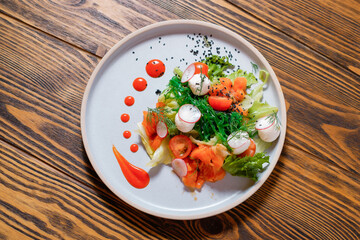 Vegetable salad with salmon, radish and tomatoes. Top view.