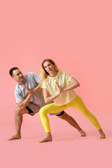 Obraz na płótnie Canvas Sporty couple practicing yoga on color background
