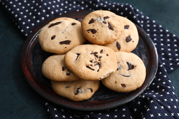 Plate with tasty homemade cookies on dark background