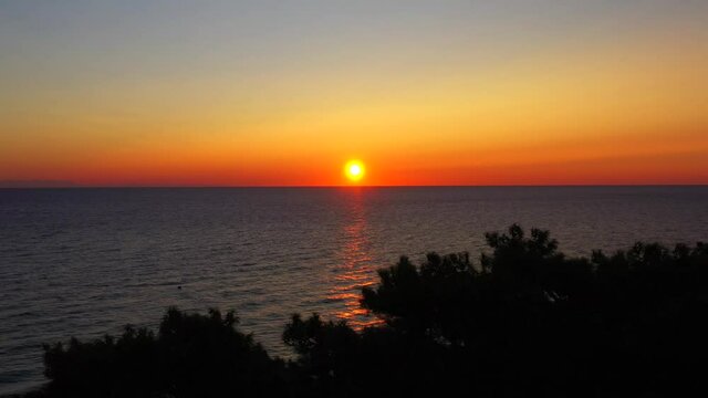 Colorful sunset above the sea surface, aerial view Mediterrenian. Reflected sun on a water surface. Sunset over ocean. Seascape, Summer and travel vacation concept