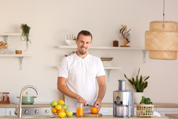 Young man preparing healthy fruit juice in kitchen - Powered by Adobe