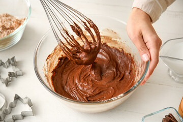 Woman preparing fresh chocolate dough on white wooden background, closeup