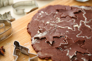 Wooden board with fresh dough for chocolate Christmas cookies on table, closeup