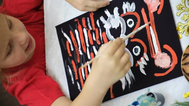 Child making funny greeting card with symbol of 2022, painting tiger.  DIY craft.
