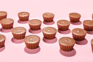 Tasty peanut butter cups on color background