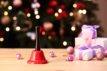 Red Christmas bell, gifts and decorations on table