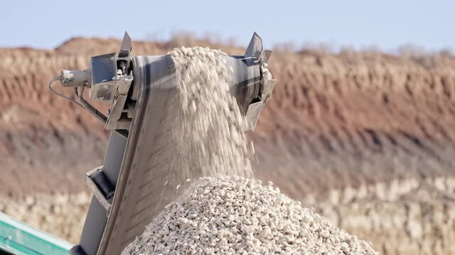 Mobile portable crushing screening plant. Mining conveyor belt sorts rock and loading stones in truck. Heavy machinery working for minerals extraction. Mining extractive industry.