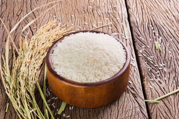organic white rice or jasmine rice in a wooden bowl, placed on a wooden floor