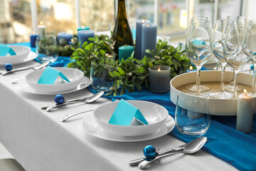 Dining table with beautiful setting for Christmas celebration and blank cards indoors
