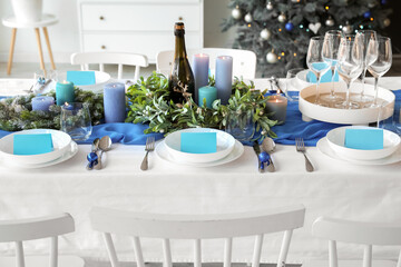 Dining table with beautiful setting for Christmas celebration and blank cards indoors