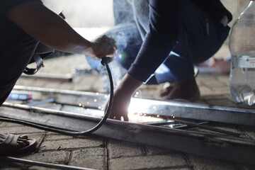a construction worker is welding iron for a building