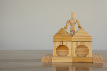 Wooden block-shaped house where puppets stand on top of a table, white background, real estate...