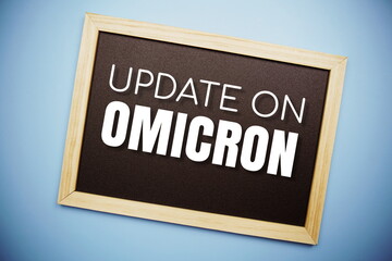 Obraz premium Update on OMICRON text on blackboard flat lay on blue background