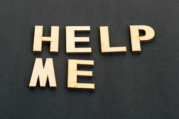 Help me symbol. Wooden cubes words help me isolated on black background, copy space. Business, motivational and help me concept.