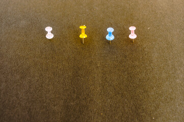 Notice Board Pin pinned attached on a brown color notice board on isolated background. High angle view.