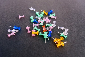 Notice Board Pin placed on a table isolated on black background. High angle view.