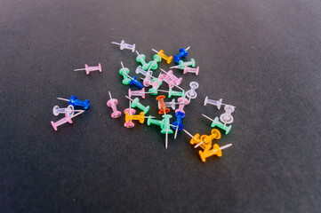 Notice Board Pin placed on a table isolated on black background. High angle view.