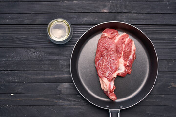 meat steak in a frying pan food ingredients kitchen wooden table