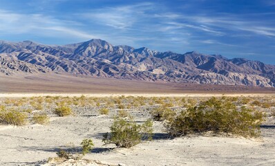 Scenic Landscape View of Panamint Range Mountain Peaks with Blue Sky and Desert Sand on a Bright Sunny Day in Death Valley National Park, California USA