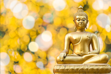 Beautiful of Ancient Golden Buddha statue on light golden yellow bokeh background,Thailand holiday concept