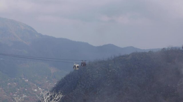 Cable cars carry people across volcanic mountains in Hakone, Japan