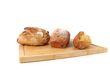 Cereal country bread, corn bread and brioche on a wooden board with white background