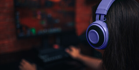 E-Sports. Girl in purple headphones Playing A Strategy Video Game. banner.