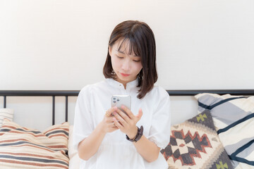 両手でスマホを持つ女性