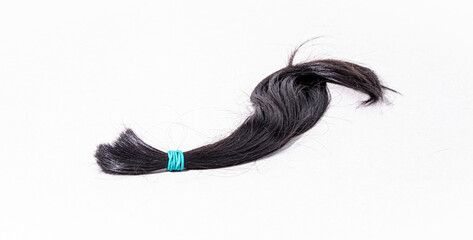 Lock of black hair on white background