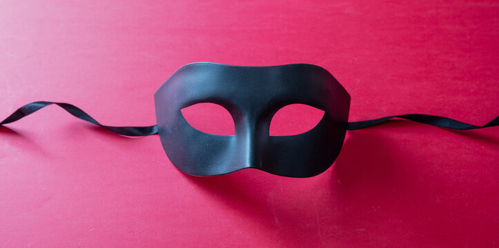Carnival Venetian black mask on red color background, disguise, masquerade