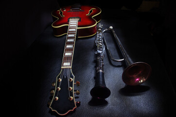 Electric guitar, clarinet and trumpet on a dark background.