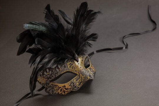 Carnival party. Venetian golden mask with feathers on black color background, masquerade, copy space