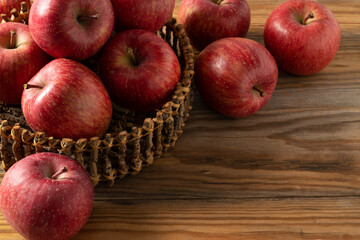 A lot of apples placed in the wooden background.