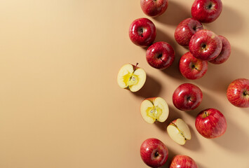 A lot of apples placed on a beige background, cut in half or quarter.