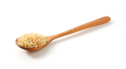 Brown rice in a wooden spoon placed on a white background.