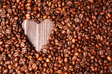 Background from coffee grains and a heart from coffee, the top view