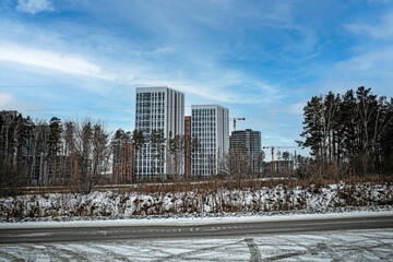 A residential neighborhood is being built near the motorway on a winter day