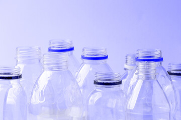 Set of diverse used empty water plastic bottles without caps on pastel pink background. Concept of recycle plastic pakaging, reuse industry, zero waste, eco-friendly
