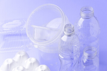 Set of diverse used empty water plastic bottles without caps on purple violet trendy background. Concept of recycle plastic pakaging, reuse industry, zero waste, eco-friendly, color of year 2022