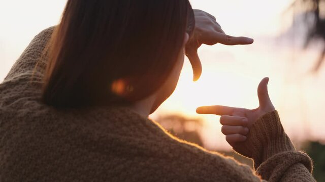 B roll - New year planning and vision concept, Close up of woman hands making frame gesture with sunset, Female capturing the sunrise.