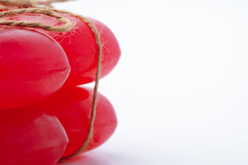 Red handmade soap bars tied with ribbon on white background