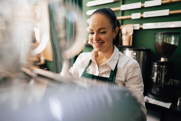 Caucasian female barista at work making coffee