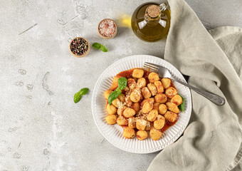 Homemade recipe gnocchi with hot tomato sauce and cheese on a white plate. Potato gnocchi is a very popular Italian food.