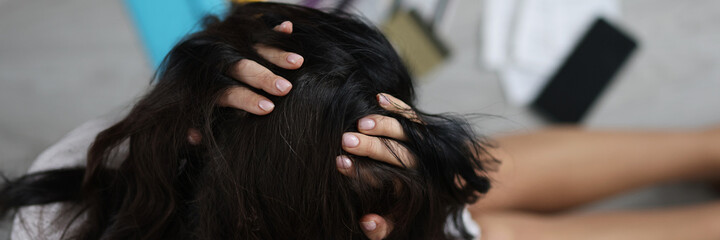 Naklejka premium Woman sitting on floor near scattered bank cards and holding her head top view