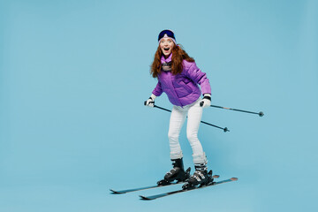 Full body skier amazed happy fun cool woman 20s wearing warm purple padded windbreaker jacket ski...