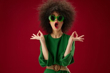 woman in green dress sunglasses fashion hairstyle red background