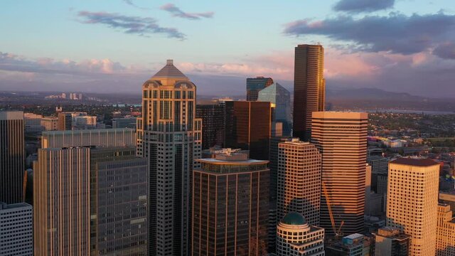 Aerial of Downtown Seattle skyscrapers during a golden hour sunset.