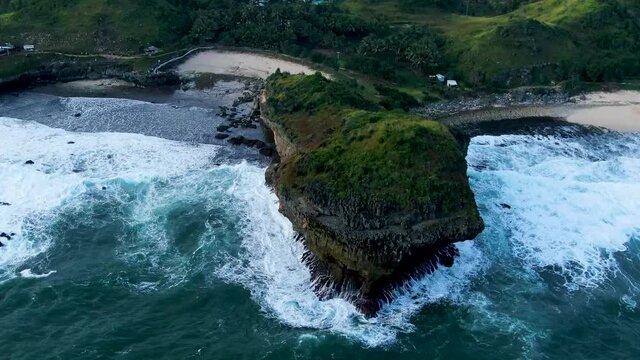 Giant volcanic rock between paradise beaches on Kasap coast, Java, Indonesia, aerial