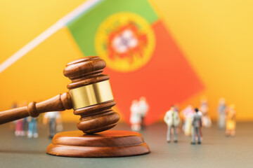 Judge gavel, flag of Portugal and plastic toy men on colored background, concept of trial in...
