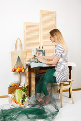 Woman is sewing shopping bags instead of plastic bags. DIY Reusable mesh shopper. Handmake of Eco bags for shopping in grocery store. Fresh fruits. Eco-friendly shopping. Zero waste. Plastic-free